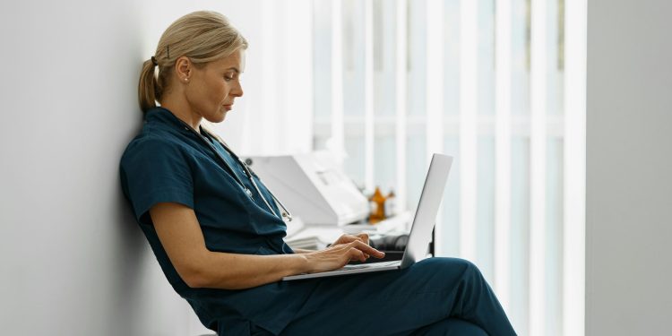 Female healthcare worker using laptop while working at doctor's office