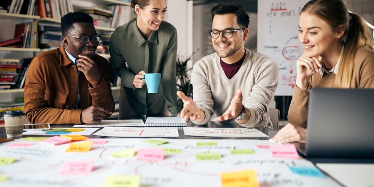 Happy creative marketing team working on new business project in the office.