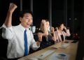 Successful asian business people celebrating success in office at night,