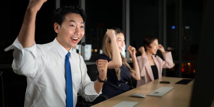 Successful asian business people celebrating success in office at night,